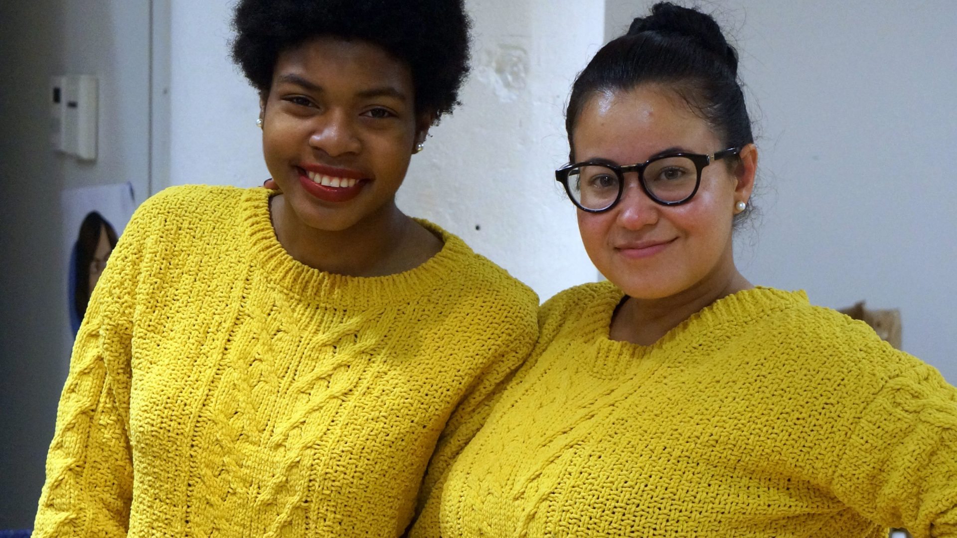 Leidy and her mentee pose for a picture, both in matching yellow sweaters