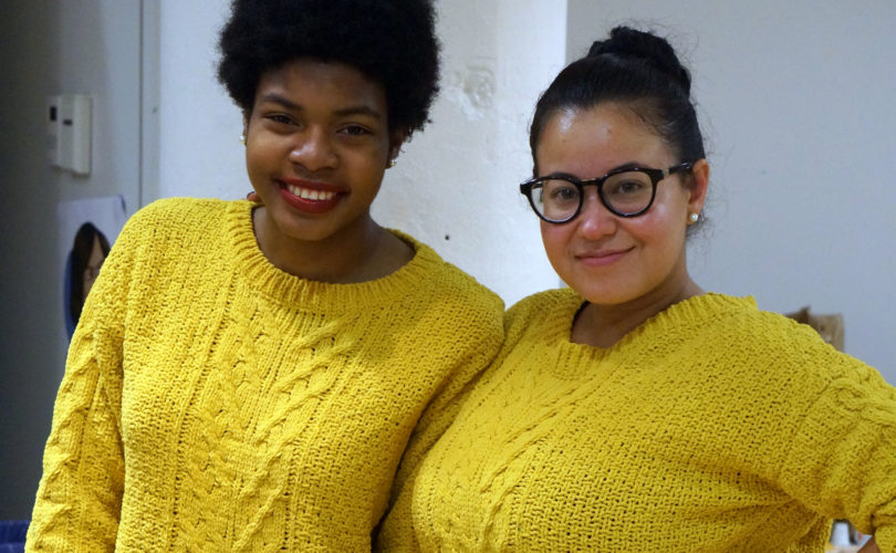 Leidy and her mentee pose for a picture, both in matching yellow sweaters