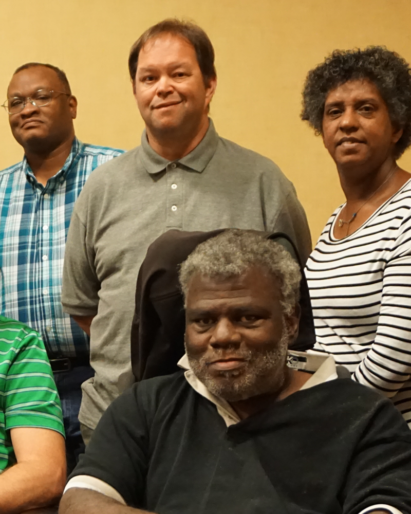 Current SABE Board members in a group picture. There are 3 people of color and 6 people people who are white. There are 3 female and 6 male persons. There are 2 people in their wheelchairs and the rest of the members are standing behind them.